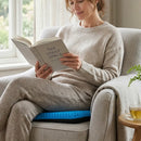 Mujer de 40 años sonriendo, sentada cómodamente en una silla de oficina con la almohada confort SitRelief, experimentando comodidad oficina y una postura saludable en su jornada laboral.